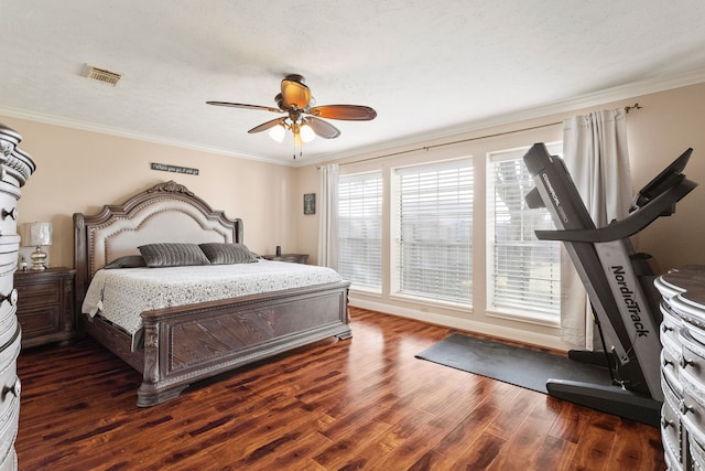 bedroom with a textured ceiling, dark hardwood / wood-style flooring, ceiling fan, and ornamental molding