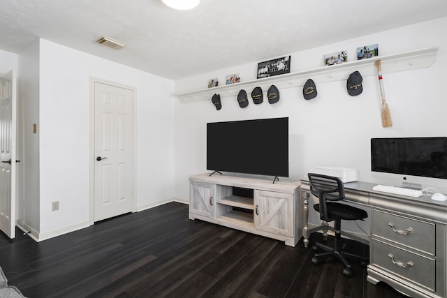 office area with a textured ceiling and dark wood-type flooring