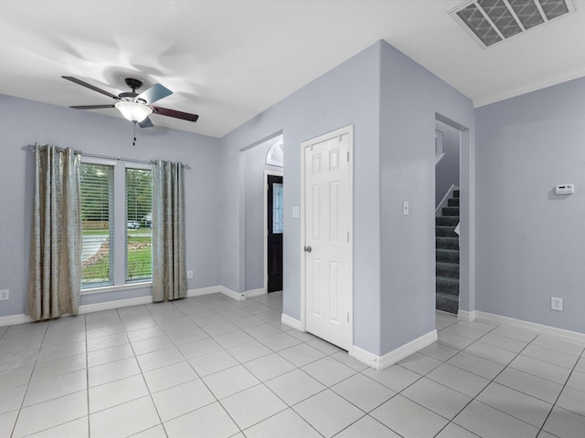 tiled spare room with ceiling fan