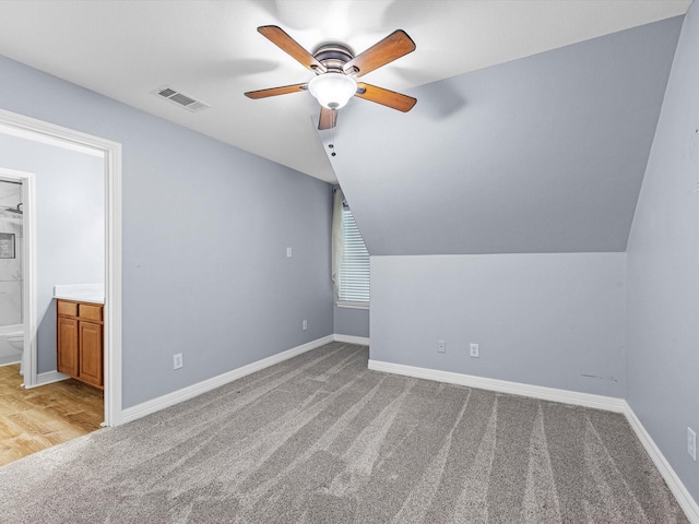 additional living space featuring ceiling fan, light colored carpet, and vaulted ceiling