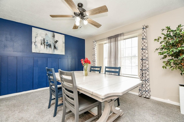 dining space with ceiling fan, carpet, and a textured ceiling