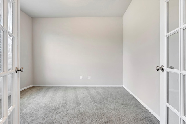 carpeted spare room featuring french doors