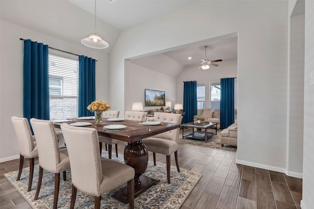 dining space featuring dark hardwood / wood-style floors, vaulted ceiling, a wealth of natural light, and ceiling fan