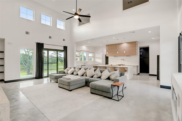 living room featuring a high ceiling and ceiling fan