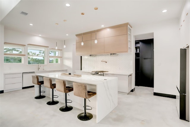 kitchen featuring a center island, backsplash, white dishwasher, hanging light fixtures, and stainless steel fridge