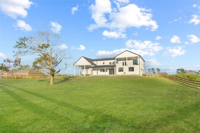 rear view of property featuring a lawn