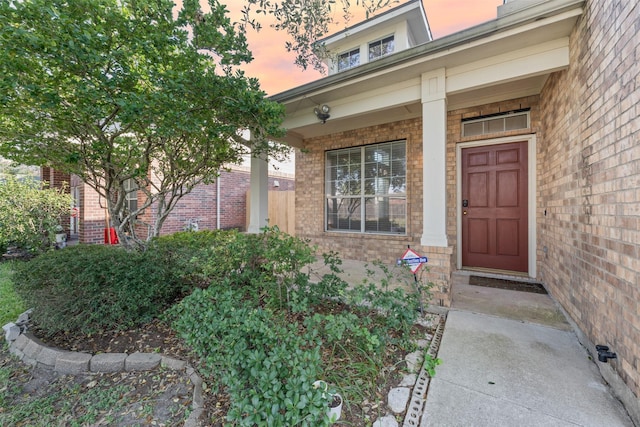 exterior entry at dusk featuring covered porch