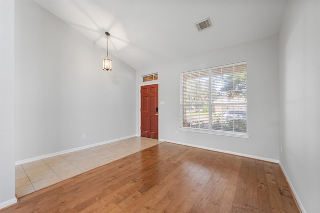 empty room featuring light hardwood / wood-style floors and vaulted ceiling