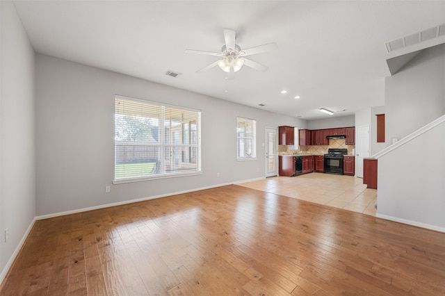 unfurnished living room featuring ceiling fan and light wood-type flooring