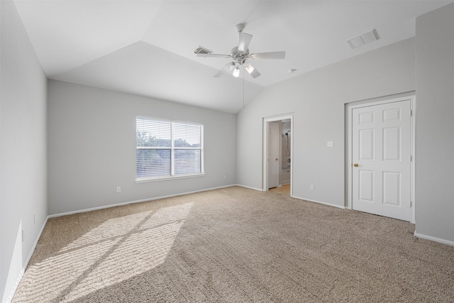 unfurnished bedroom with ceiling fan, ensuite bath, light carpet, and vaulted ceiling