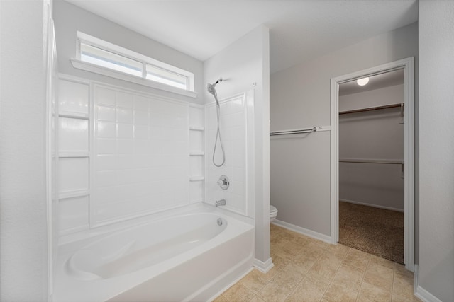 bathroom featuring washtub / shower combination and toilet