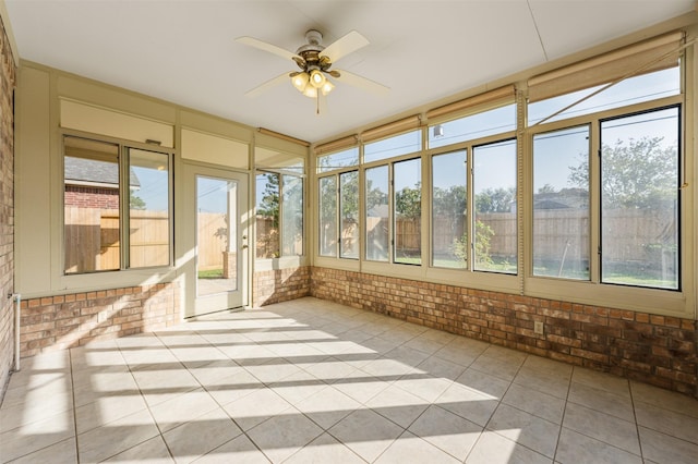 unfurnished sunroom with ceiling fan and a healthy amount of sunlight