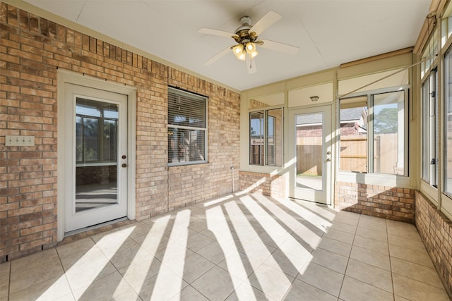 unfurnished sunroom with ceiling fan