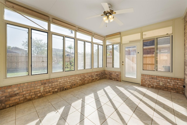 unfurnished sunroom featuring ceiling fan