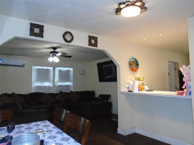 dining space with ceiling fan, dark wood-type flooring, and a wall unit AC