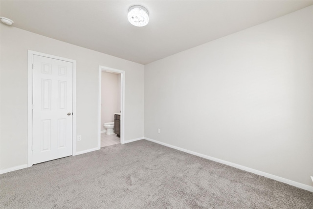 unfurnished bedroom with carpet and connected bathroom