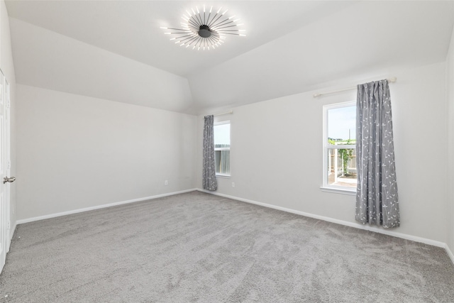 empty room featuring carpet floors and lofted ceiling