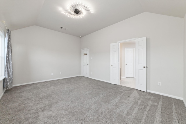 unfurnished bedroom with light colored carpet and vaulted ceiling