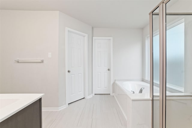 bathroom with vanity and a bath