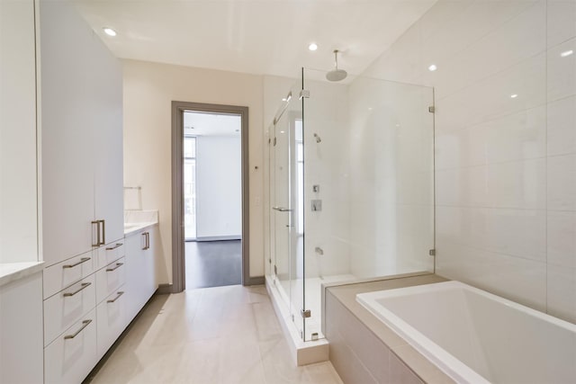 bathroom with tile patterned flooring, vanity, and separate shower and tub