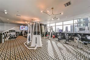 exercise room with floor to ceiling windows and a chandelier