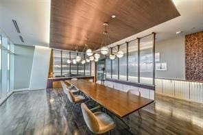 unfurnished dining area with a wall of windows, wooden ceiling, and hardwood / wood-style flooring