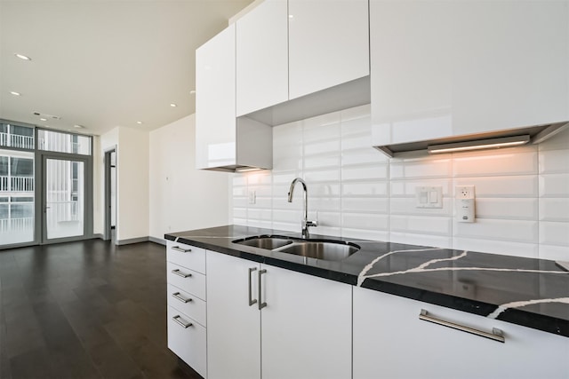 kitchen with white cabinets, expansive windows, and sink