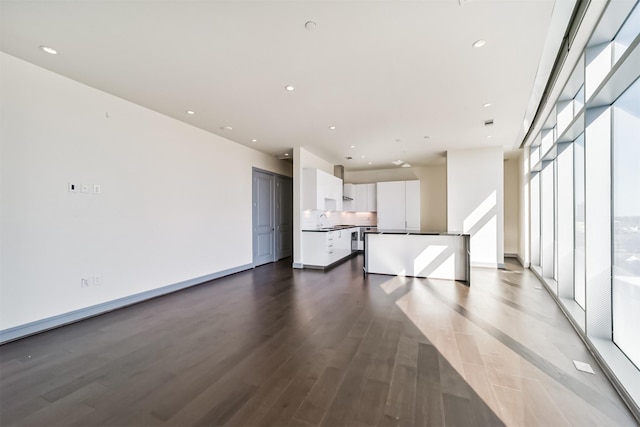 unfurnished living room featuring dark hardwood / wood-style flooring, floor to ceiling windows, and sink