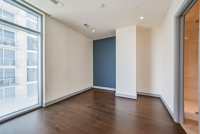 empty room featuring dark hardwood / wood-style floors and expansive windows