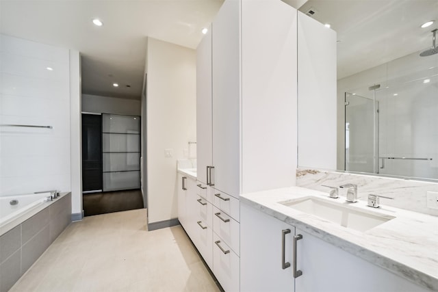 bathroom with tile patterned flooring, vanity, and plus walk in shower