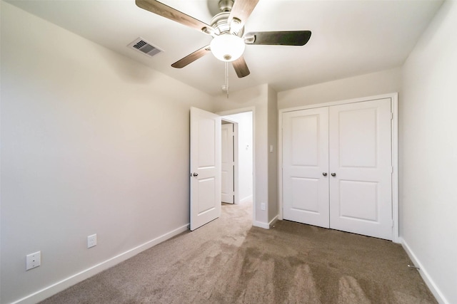 unfurnished bedroom with carpet flooring, ceiling fan, and a closet