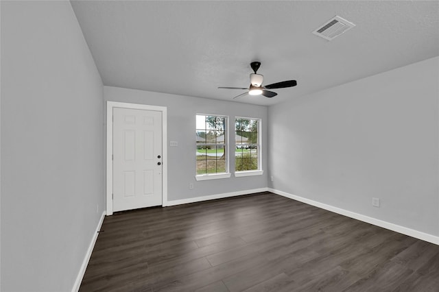 empty room featuring a textured ceiling, dark hardwood / wood-style floors, and ceiling fan