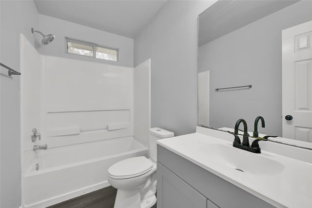 full bathroom featuring hardwood / wood-style floors, vanity,  shower combination, and toilet