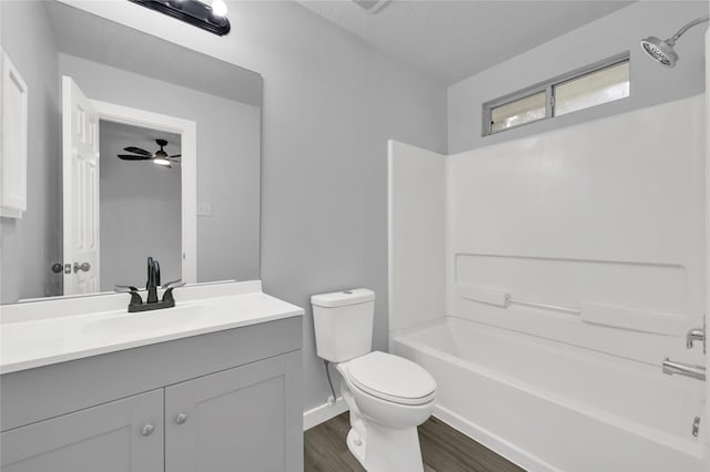 full bathroom with vanity, bathing tub / shower combination, ceiling fan, toilet, and wood-type flooring