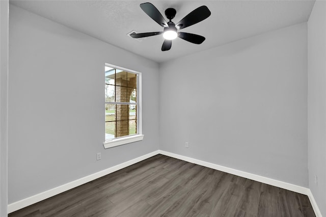 empty room with ceiling fan and dark hardwood / wood-style flooring