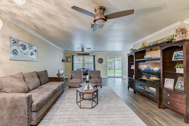 living room with wood-type flooring, a textured ceiling, ceiling fan, and crown molding