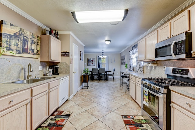 kitchen with backsplash, crown molding, sink, and stainless steel appliances