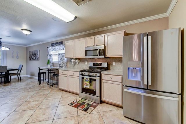 kitchen featuring decorative backsplash, light brown cabinetry, ornamental molding, and appliances with stainless steel finishes