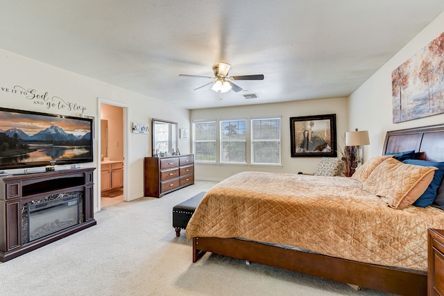 carpeted bedroom featuring ceiling fan and ensuite bath