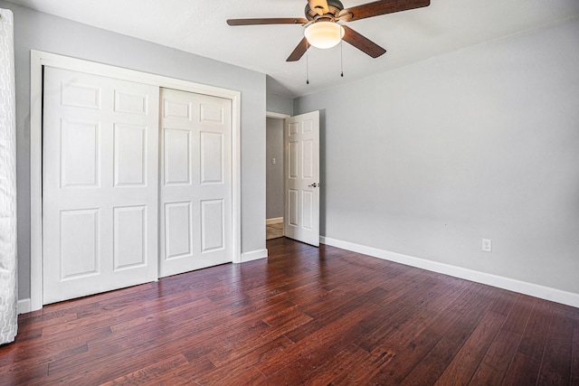 unfurnished bedroom featuring ceiling fan, a closet, and dark wood-type flooring