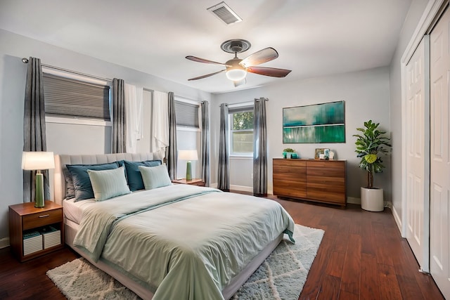 bedroom with ceiling fan, dark wood-type flooring, and a closet