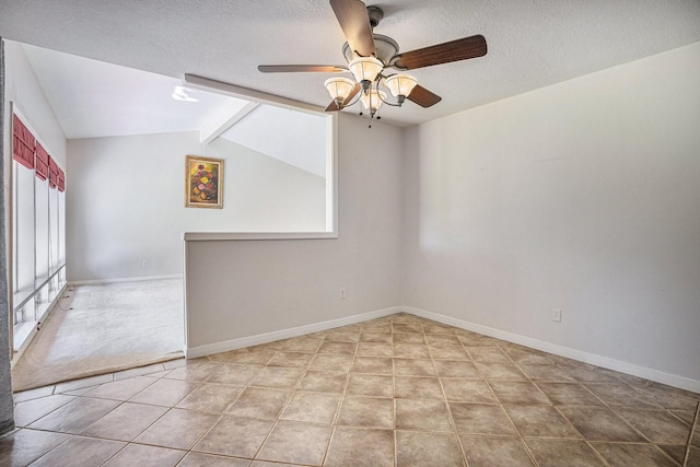 carpeted spare room featuring a textured ceiling, lofted ceiling with beams, and ceiling fan