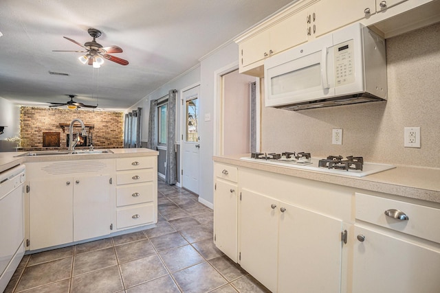 kitchen featuring white cabinets, crown molding, white appliances, and sink