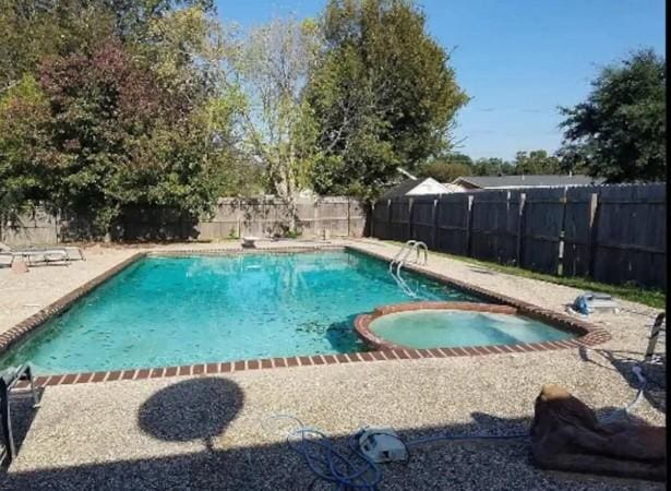 view of swimming pool featuring an in ground hot tub