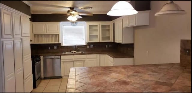 kitchen featuring stainless steel dishwasher, decorative light fixtures, white cabinets, and range