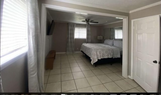 bedroom with ceiling fan, crown molding, and light tile patterned floors