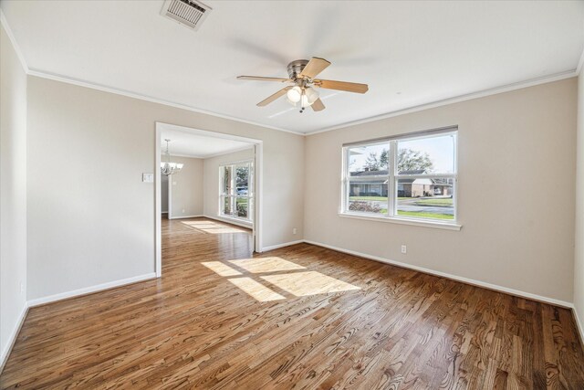 empty room with crown molding, ceiling fan with notable chandelier, and hardwood / wood-style flooring