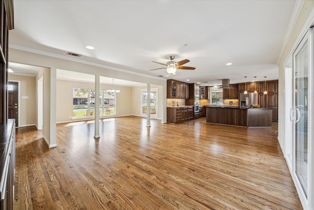 unfurnished living room with crown molding, light hardwood / wood-style flooring, and ceiling fan with notable chandelier