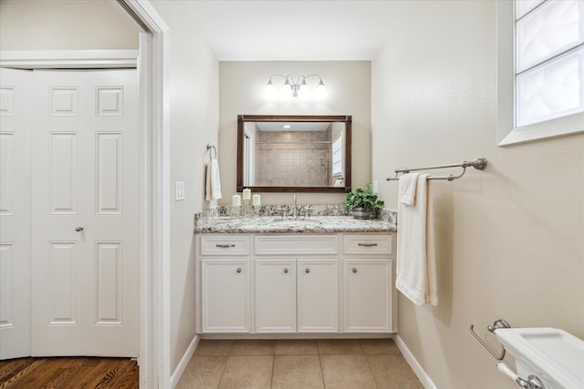 bathroom with tile patterned flooring, vanity, and toilet