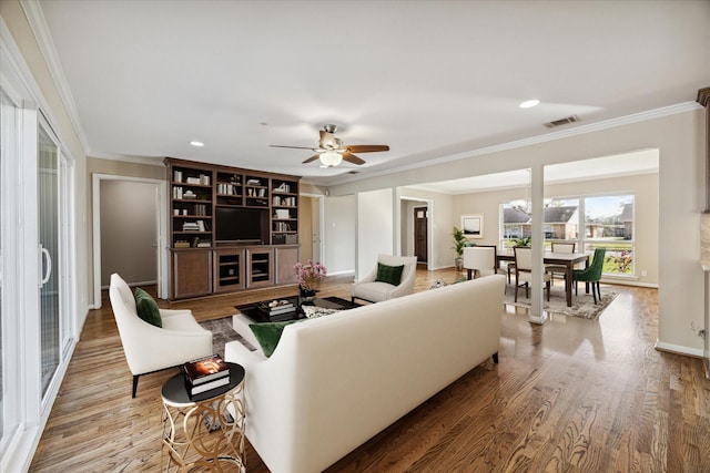 living room with ceiling fan, hardwood / wood-style flooring, and ornamental molding